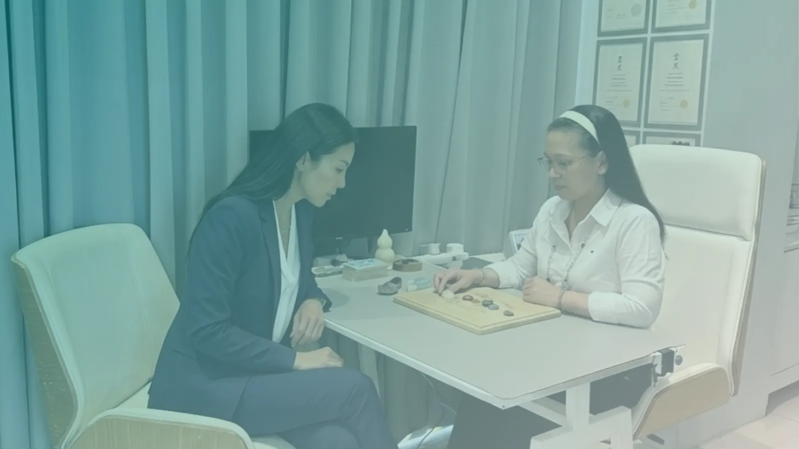 Aileen guiding a client through a session at the studio table