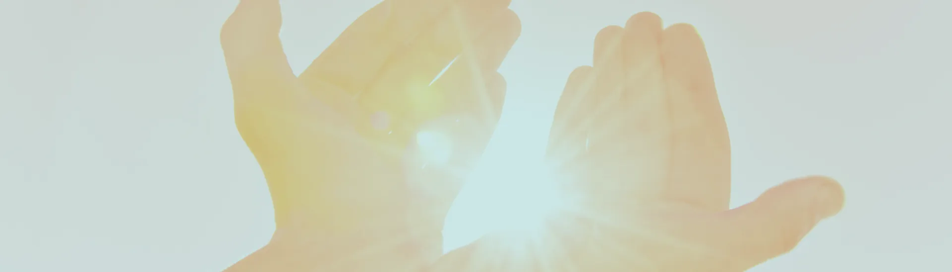 Open hands held up to warm sunlight