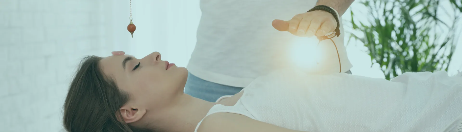 A client resting during a Reiki session with a crystal pendulum